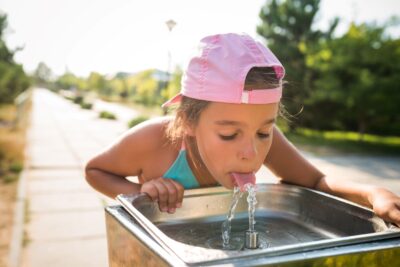 cute-thirsty-girl-drinks-water-from-drinking-sink-2022-02-02-03-56-00-utc